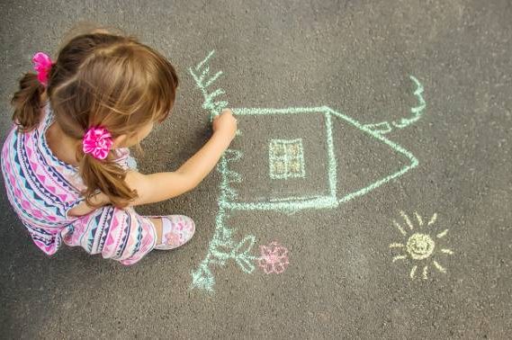 the-child-draws-the-house-with-chalk-on-the-asphalt-selective-focus